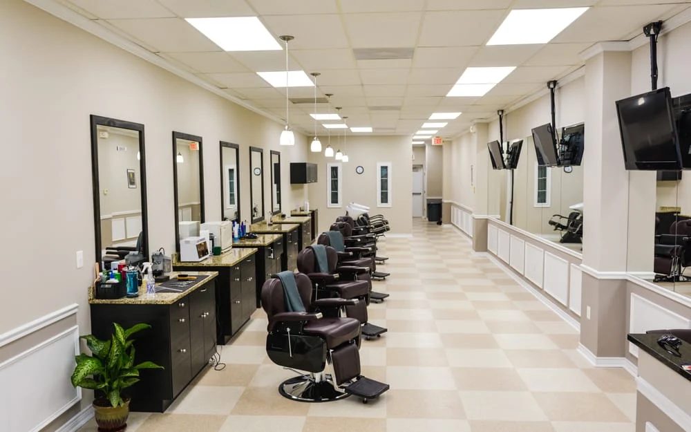 The row of barber chairs and mirrored stations, looking down the length of the shop.
