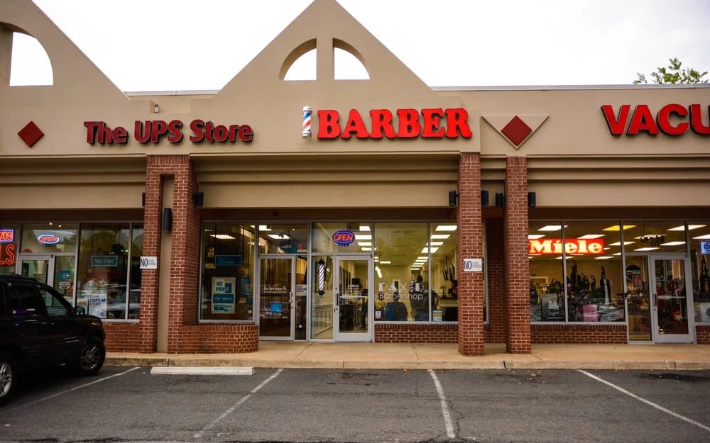 The shop front in Piedmont Square, next door to the UPS Store, with the barber pole above the window.