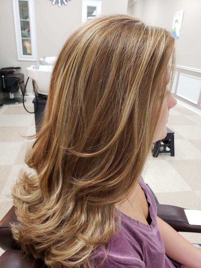 Long blonde highlights, layered and blown out.