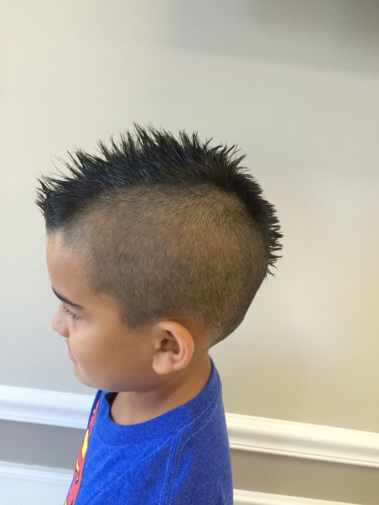 A young boy's faux hawk, tight at the sides.